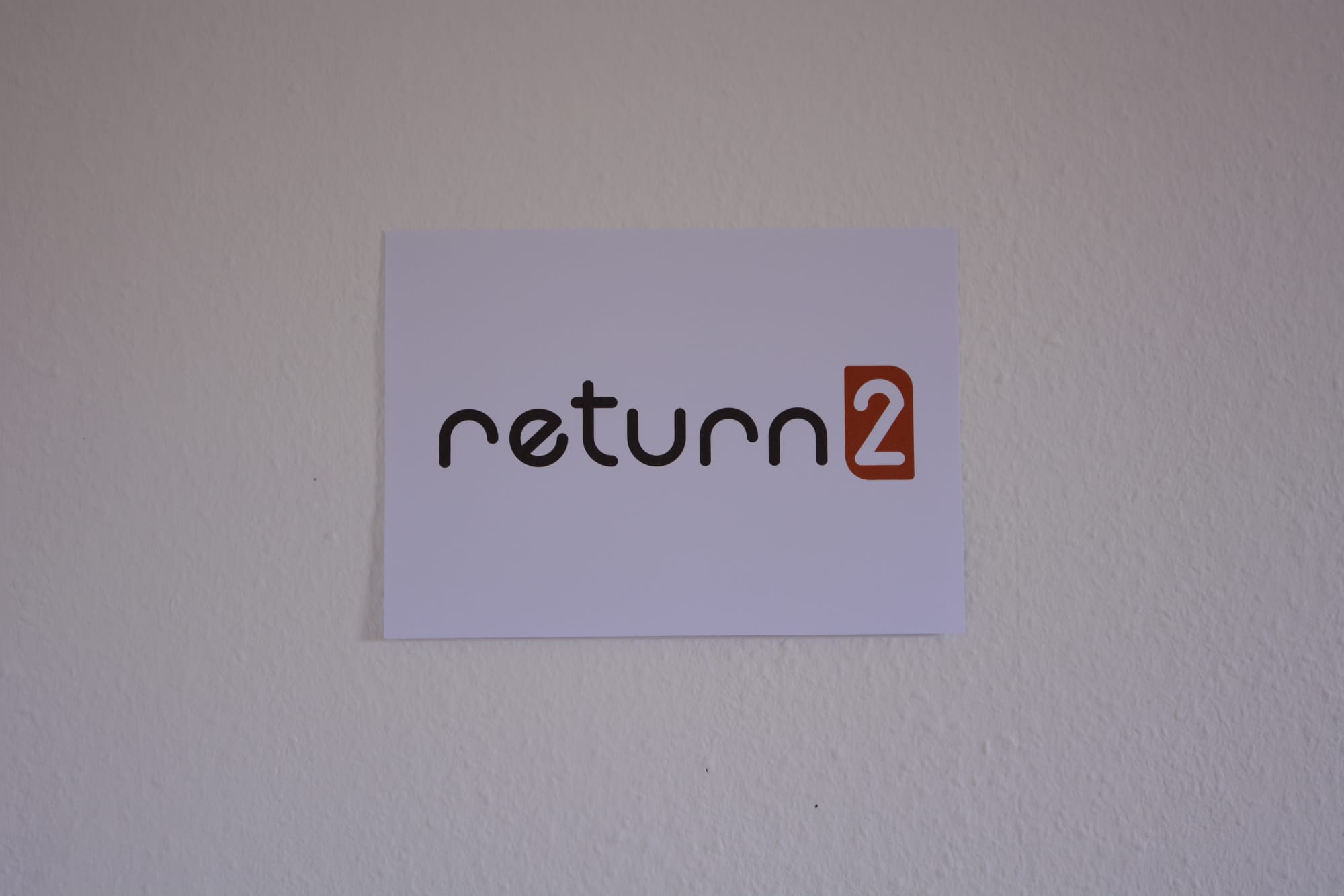 A picture of the return2 logo without a pink horizontal line